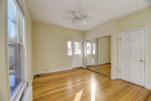 unfurnished bedroom with ceiling fan, a closet, and light hardwood / wood-style flooring