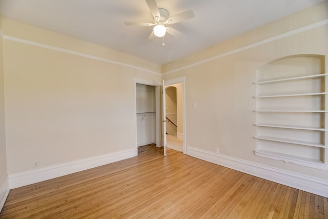 spare room featuring crown molding, ceiling fan, hardwood / wood-style floors, and built in features