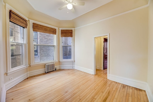 unfurnished room with ceiling fan, radiator, and light hardwood / wood-style floors