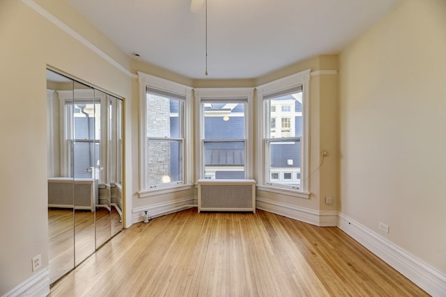 unfurnished dining area featuring hardwood / wood-style flooring and radiator heating unit