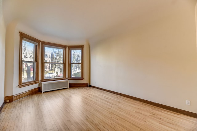 spare room with radiator and light wood-type flooring