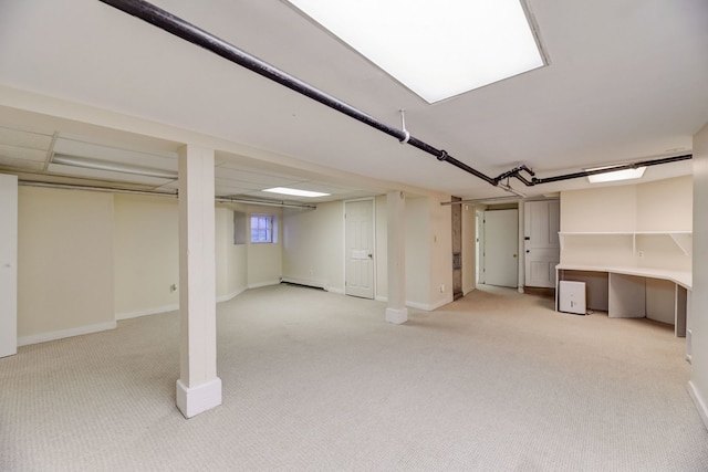 basement with baseboard heating and light colored carpet