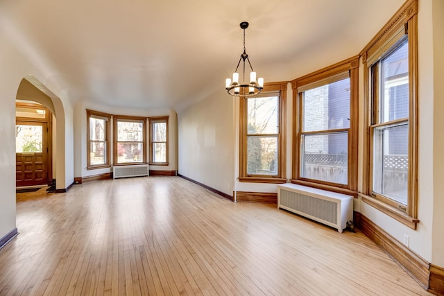 interior space featuring radiator heating unit and light hardwood / wood-style floors