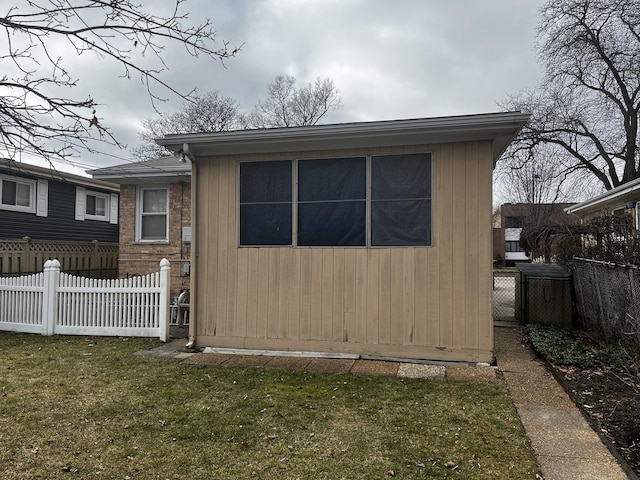 view of home's exterior with an outbuilding and a lawn