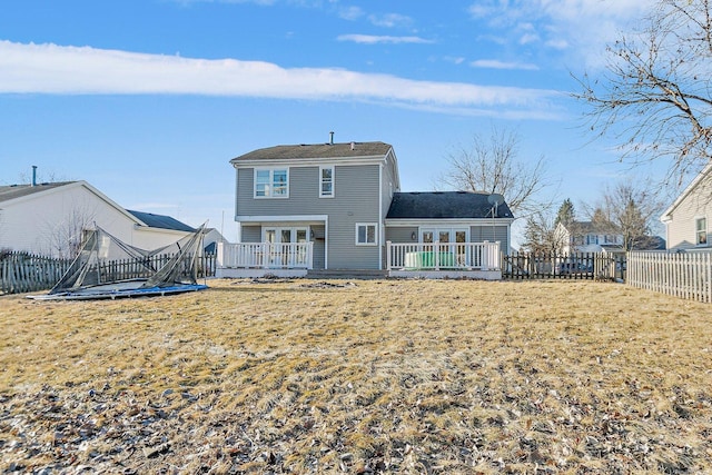 back of house with a yard, a deck, a trampoline, and french doors