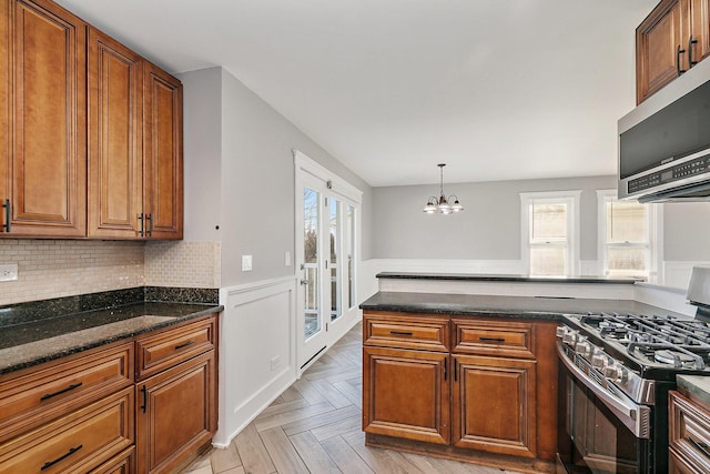 kitchen with light parquet flooring, appliances with stainless steel finishes, a healthy amount of sunlight, and pendant lighting