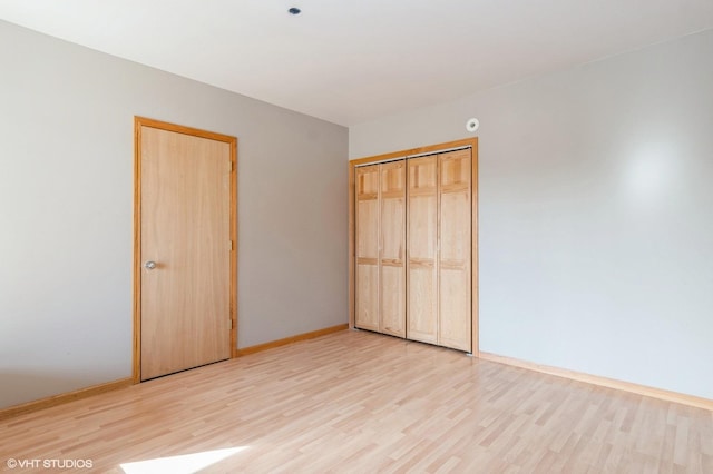 unfurnished bedroom featuring a closet and light wood-type flooring