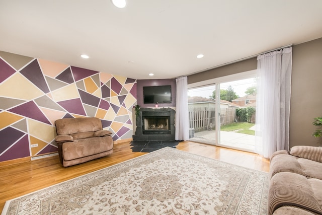 living room featuring hardwood / wood-style flooring and a tiled fireplace