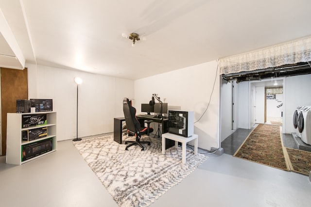 office area featuring concrete flooring and washing machine and dryer