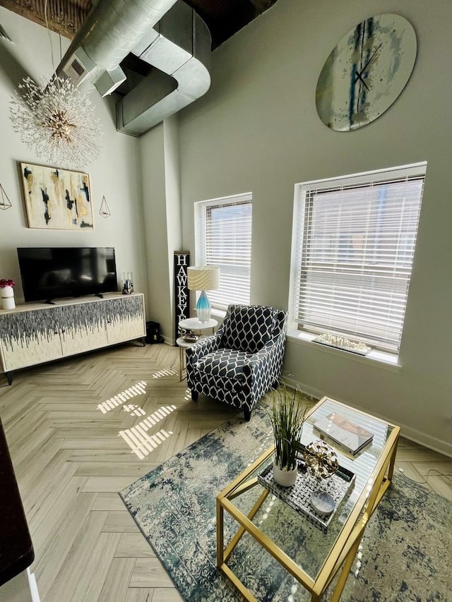 living room with a high ceiling and baseboards