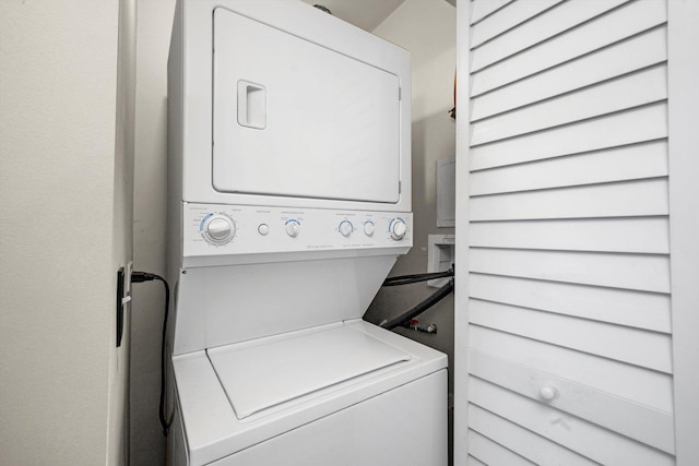 clothes washing area with stacked washer / dryer