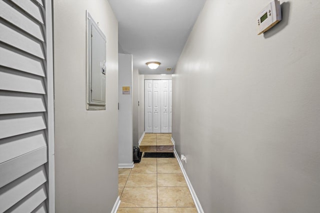 hall with light tile patterned flooring and electric panel