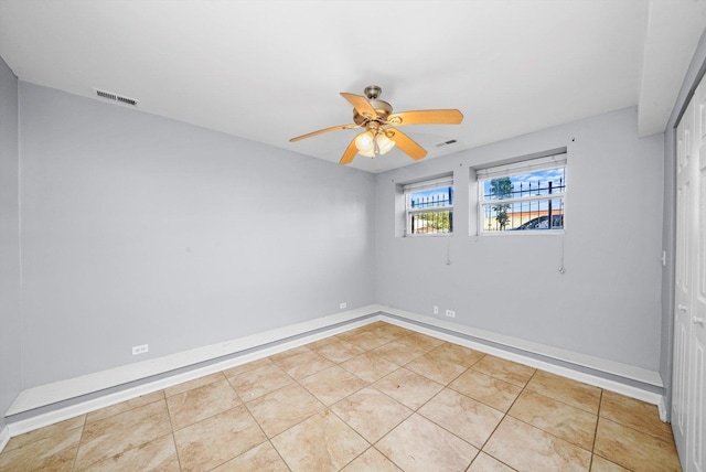 unfurnished room with ceiling fan and light tile patterned flooring