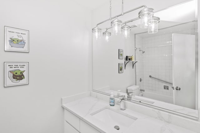 full bathroom featuring tiled shower / bath combo, vanity, and toilet