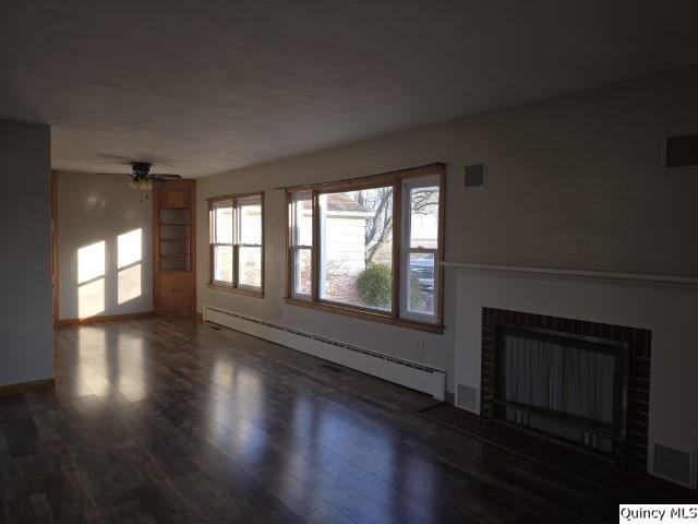 unfurnished living room with ceiling fan, dark wood-type flooring, and baseboard heating