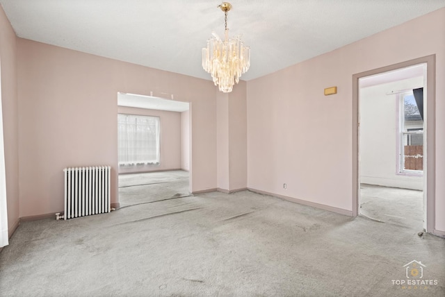 carpeted empty room featuring an inviting chandelier and radiator