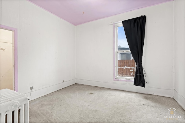 carpeted empty room with radiator heating unit