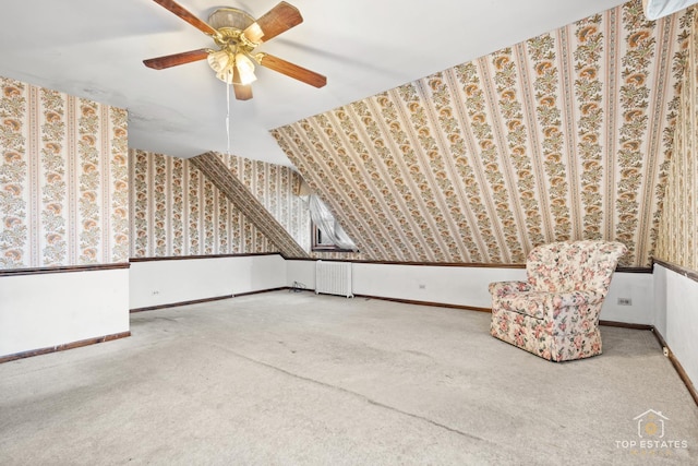 additional living space with radiator, ceiling fan, and carpet flooring