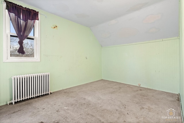 bonus room with radiator, vaulted ceiling, and carpet