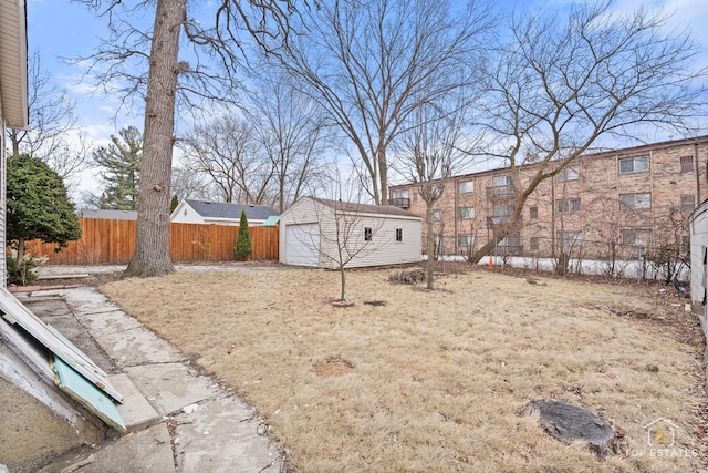 view of yard with a garage and an outbuilding