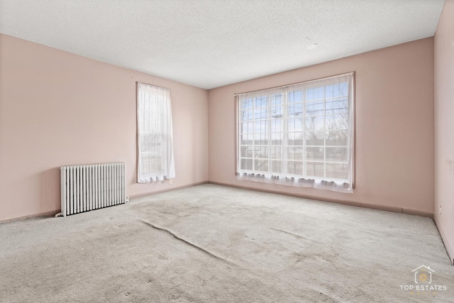 unfurnished room featuring radiator heating unit, a textured ceiling, and carpet