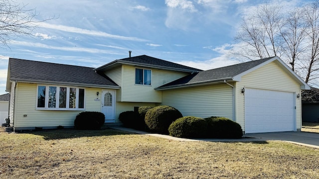 split level home featuring a garage and a front lawn