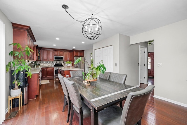 dining area featuring a notable chandelier and dark wood-type flooring