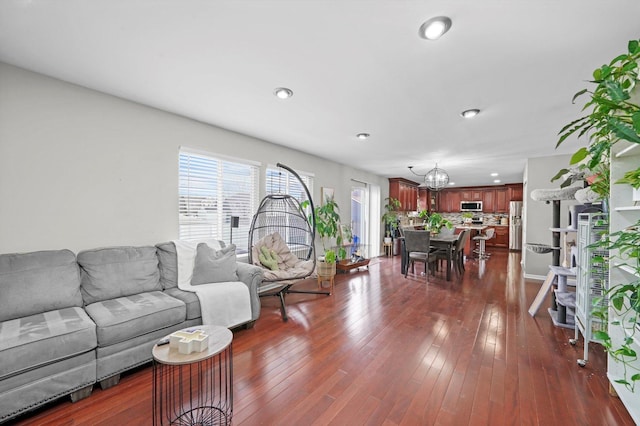 living room featuring dark wood-type flooring and a chandelier