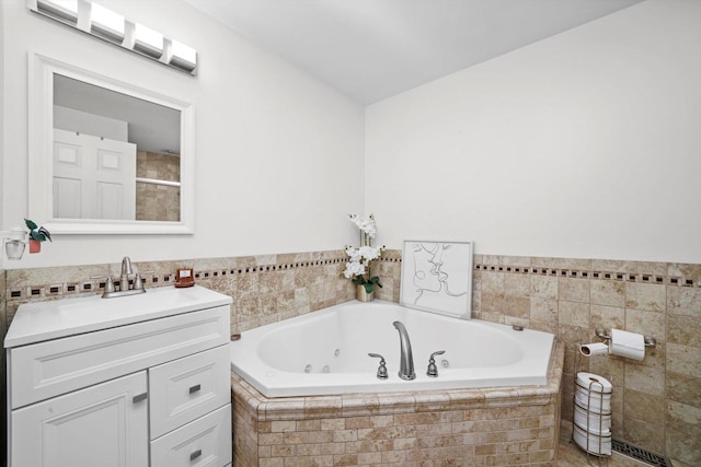 bathroom with vanity and tiled bath