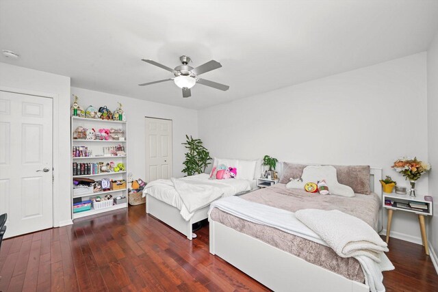 bedroom featuring dark wood-type flooring, ceiling fan, and a closet