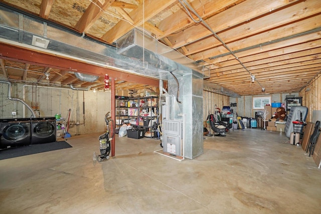 basement with heating unit and washer and clothes dryer