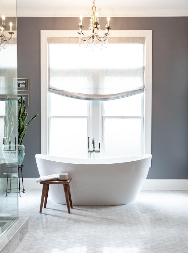 bathroom featuring crown molding, a tub, and a chandelier