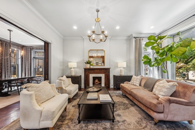 living room with dark hardwood / wood-style floors, ornamental molding, a high end fireplace, and a chandelier