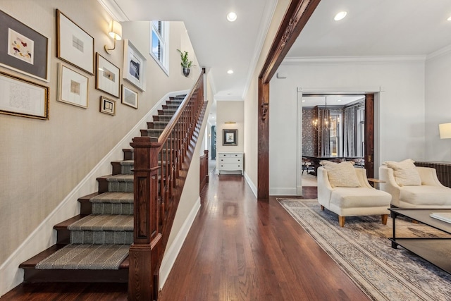 entrance foyer featuring ornamental molding, plenty of natural light, dark wood-type flooring, and an inviting chandelier