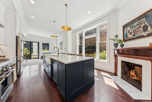 kitchen featuring sink, crown molding, an island with sink, pendant lighting, and stainless steel appliances