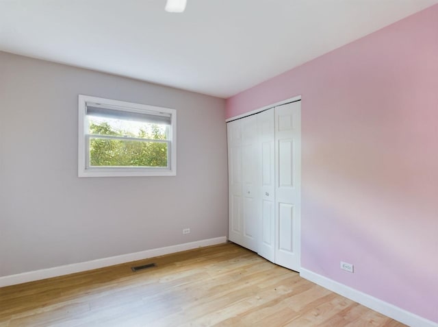 unfurnished bedroom with a closet and light wood-type flooring