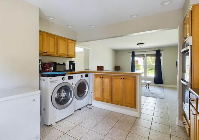 laundry area with washer and dryer and light tile patterned floors