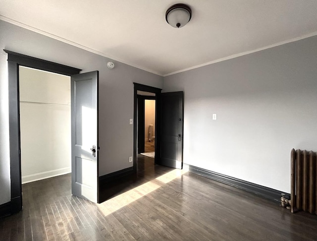 unfurnished bedroom featuring dark hardwood / wood-style flooring, radiator heating unit, and ornamental molding