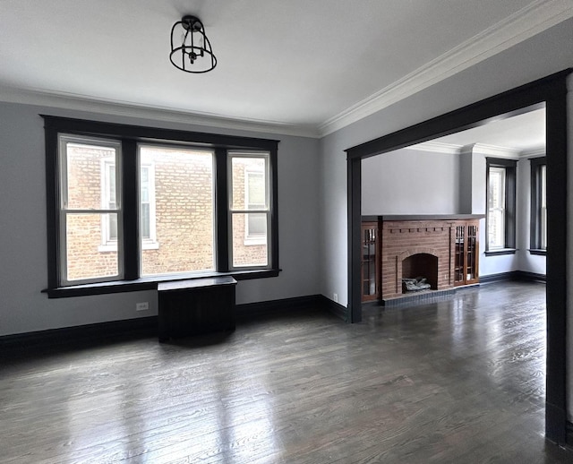 unfurnished living room with crown molding, dark hardwood / wood-style flooring, and a fireplace