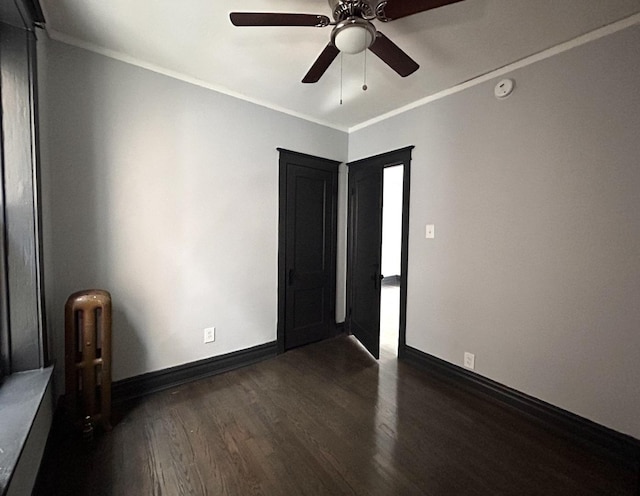 unfurnished bedroom with crown molding, ceiling fan, radiator heating unit, and dark hardwood / wood-style floors