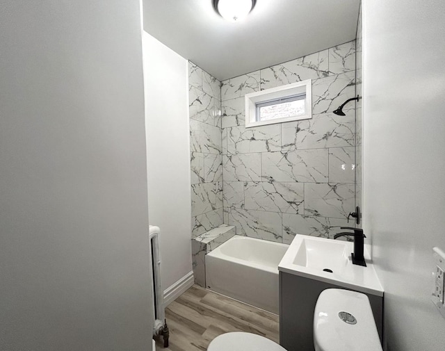 full bathroom featuring tiled shower / bath combo, vanity, hardwood / wood-style floors, and toilet