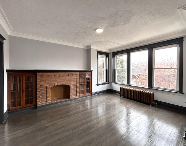 unfurnished living room with dark wood-type flooring, ornamental molding, radiator heating unit, and a fireplace