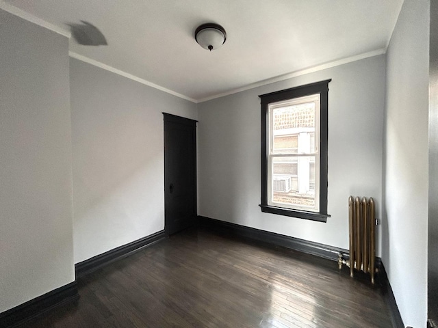 spare room featuring ornamental molding, dark hardwood / wood-style floors, and radiator