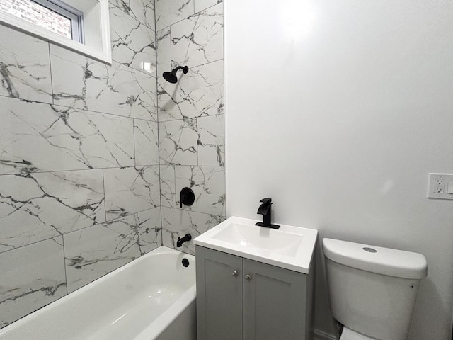 full bathroom with vanity, tiled shower / bath combo, and toilet