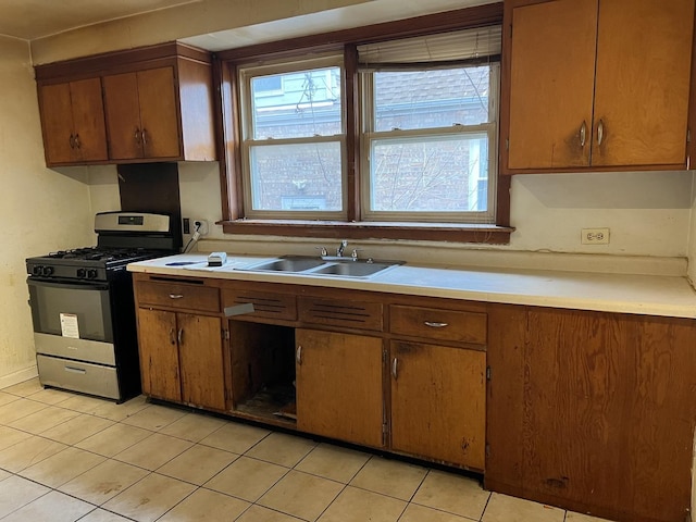 kitchen with sink, stainless steel range with gas cooktop, and light tile patterned flooring