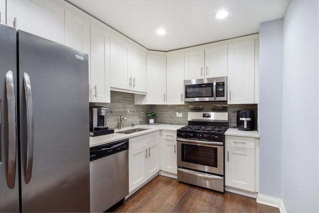 kitchen with stainless steel appliances, sink, white cabinets, and dark hardwood / wood-style floors