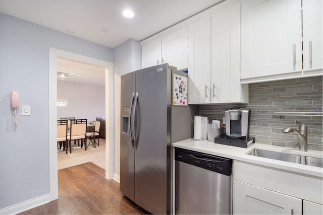 kitchen featuring dark wood-type flooring, sink, tasteful backsplash, stainless steel appliances, and white cabinets