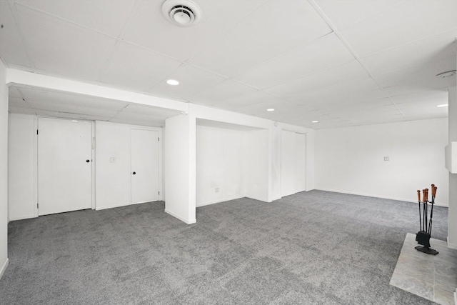 basement featuring carpet floors and a drop ceiling