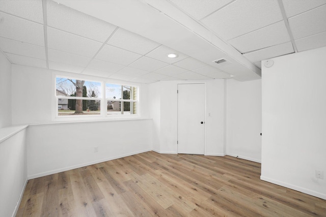 interior space with hardwood / wood-style floors and a drop ceiling