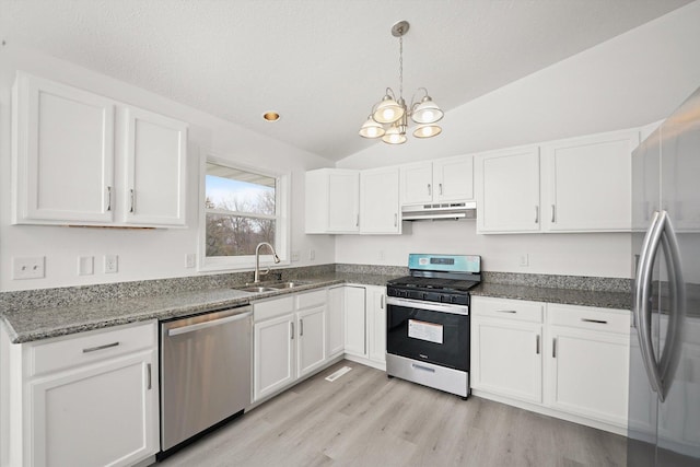 kitchen with lofted ceiling, appliances with stainless steel finishes, sink, and white cabinets